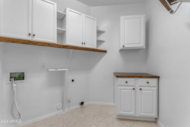 washroom featuring light tile patterned flooring, cabinets, washer hookup, hookup for an electric dryer, and hookup for a gas dryer