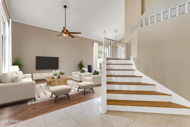 staircase with high vaulted ceiling, tile patterned floors, and ceiling fan