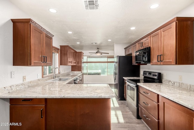 16638 N 46th Ln, Glendale, AZ 85306 - kitchen featuring visible vents, a sink, electric stove, brown cabinetry, and black microwave