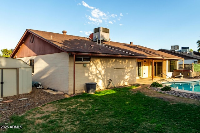 16638 N 46th Ln, Glendale, AZ 85306 - back of house with a hot tub, cooling unit, a yard, an outdoor structure, and a storage unit