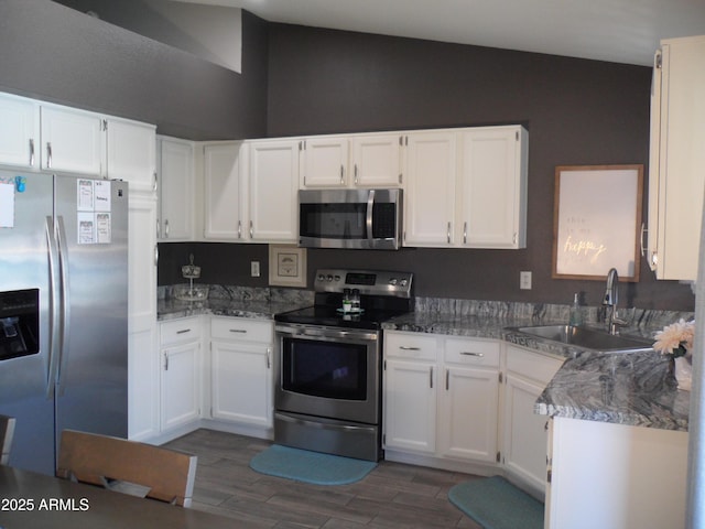 1333 N Higley Rd Unit 7, Mesa, AZ 85205 - kitchen featuring appliances with stainless steel finishes, a sink, lofted ceiling, white cabinets, and dark wood finished floors