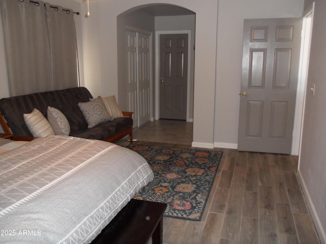 1333 N Higley Rd Unit 7, Mesa, AZ 85205 - bedroom featuring arched walkways, baseboards, and wood finished floors