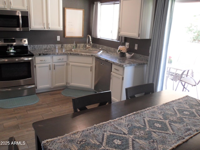 1333 N Higley Rd Unit 7, Mesa, AZ 85205 - kitchen featuring stainless steel appliances, a sink, white cabinetry, and wood finished floors