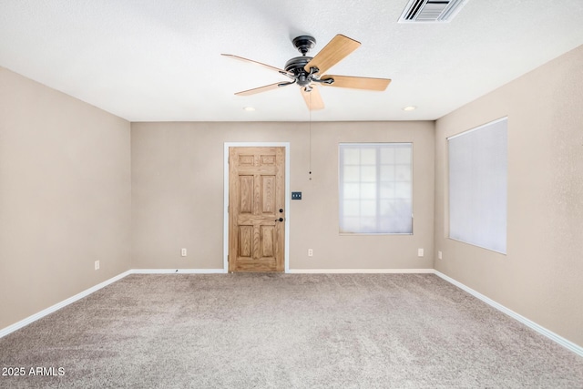 spare room featuring ceiling fan, carpet, visible vents, and baseboards