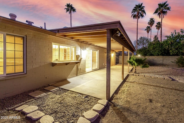 patio terrace at dusk featuring a fenced backyard