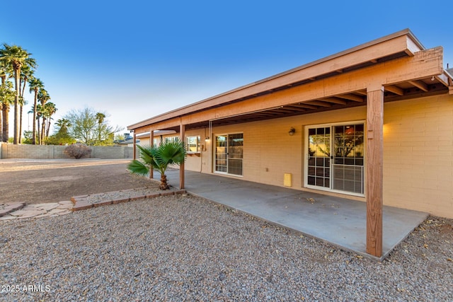 rear view of house with a patio area and fence