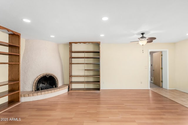 unfurnished living room featuring light wood-style floors, a large fireplace, and recessed lighting