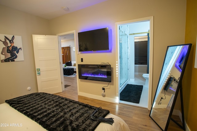 bedroom featuring ensuite bathroom and light hardwood / wood-style flooring