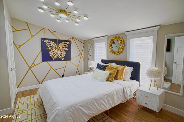 bedroom featuring hardwood / wood-style floors and an inviting chandelier