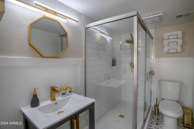 bathroom featuring tile patterned floors, vanity, toilet, and walk in shower