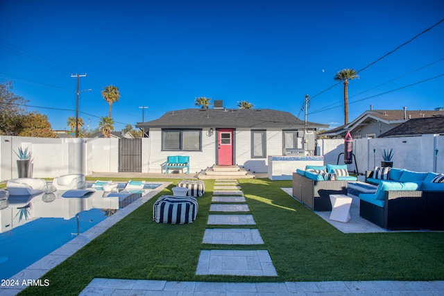 rear view of property featuring a lawn, an outdoor living space, and a swimming pool