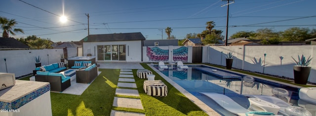 view of swimming pool featuring outdoor lounge area, a patio area, an outbuilding, and a yard