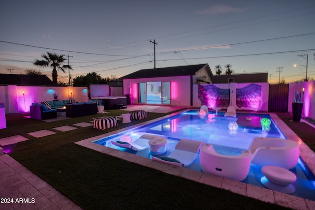 pool at dusk with an outdoor living space, an outbuilding, and a patio