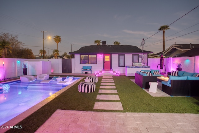 exterior space featuring a fenced in pool, an outdoor living space with a fire pit, and a patio