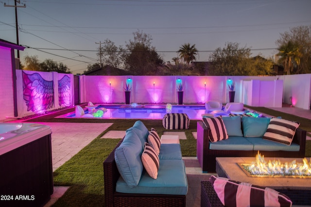 patio terrace at dusk featuring an outdoor living space with a fire pit and a swimming pool