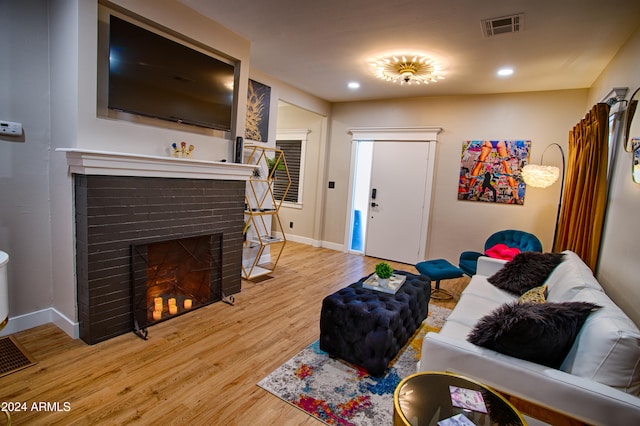 living room featuring hardwood / wood-style flooring and a brick fireplace