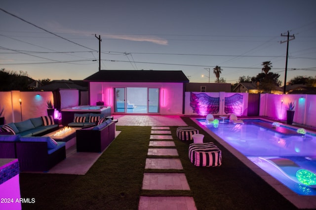 patio terrace at dusk featuring a fire pit and a pool