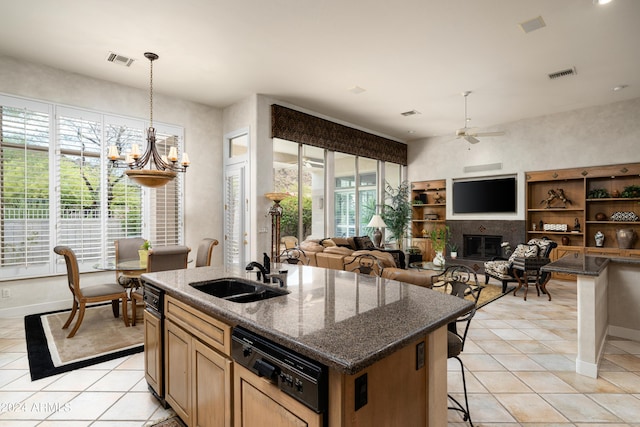 kitchen featuring paneled dishwasher, ceiling fan, sink, a center island with sink, and a breakfast bar area