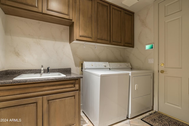 clothes washing area with cabinets, separate washer and dryer, and sink