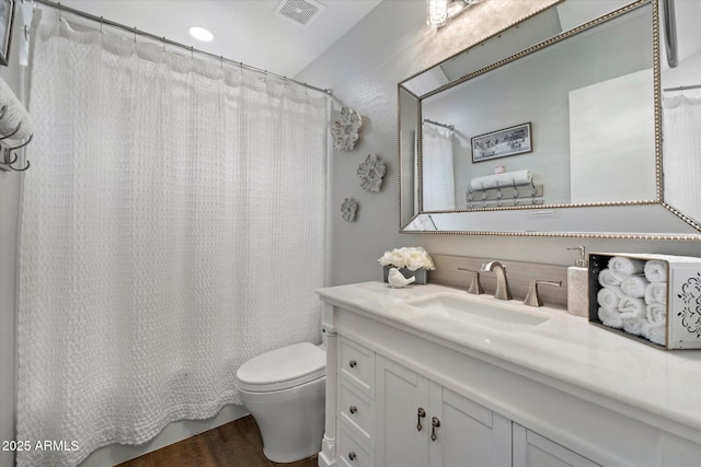 bathroom with toilet, wood finished floors, and vanity