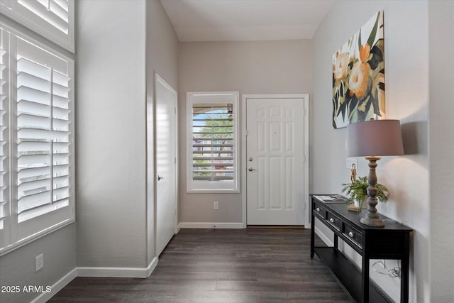 foyer entrance with dark wood finished floors and baseboards