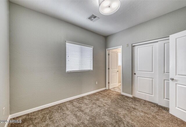 815 E Rose Ln Unit 105, Phoenix, AZ 85014 - unfurnished bedroom with a closet, baseboards, visible vents, and carpet floors