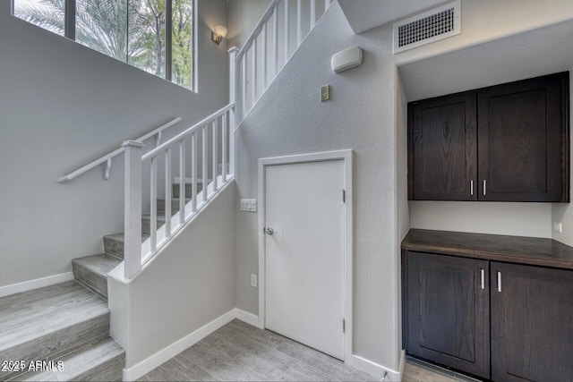 815 E Rose Ln Unit 105, Phoenix, AZ 85014 - staircase with visible vents, baseboards, and wood finished floors