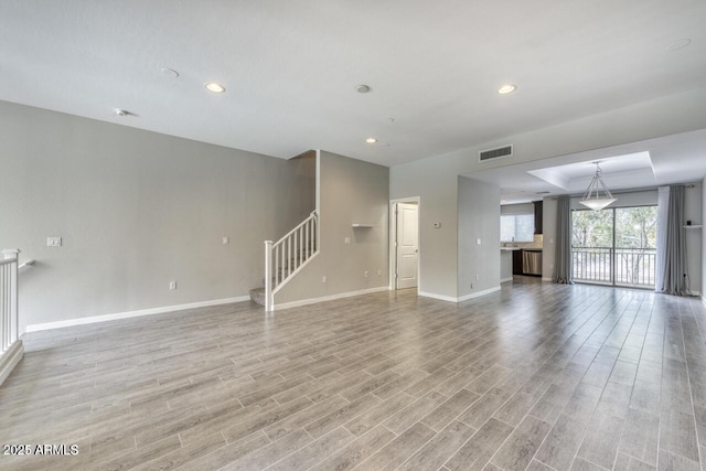 815 E Rose Ln Unit 105, Phoenix, AZ 85014 - unfurnished living room featuring light wood-style floors, stairs, visible vents, and baseboards
