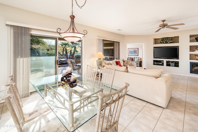 dining area featuring ceiling fan, built in features, and light tile patterned floors