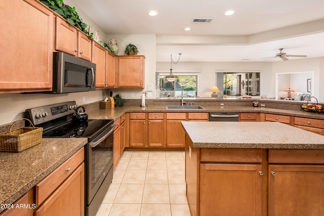 kitchen with ceiling fan, sink, a center island, and stainless steel appliances