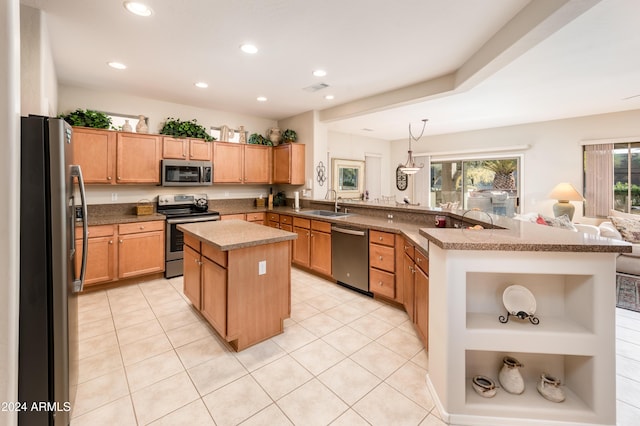 kitchen featuring sink, decorative light fixtures, a kitchen island, kitchen peninsula, and stainless steel appliances