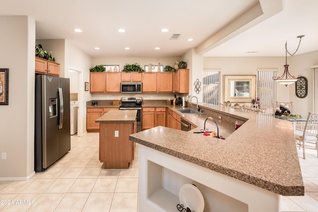 kitchen featuring kitchen peninsula, stainless steel appliances, sink, light tile patterned floors, and a kitchen island