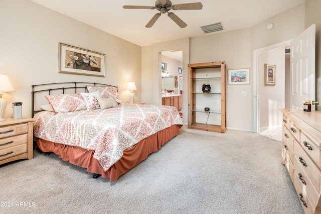 bedroom featuring ensuite bathroom, ceiling fan, and light colored carpet