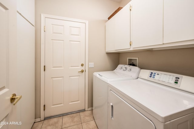 clothes washing area featuring light tile patterned flooring, cabinets, and independent washer and dryer