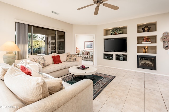 living room with built in shelves, light tile patterned floors, and ceiling fan