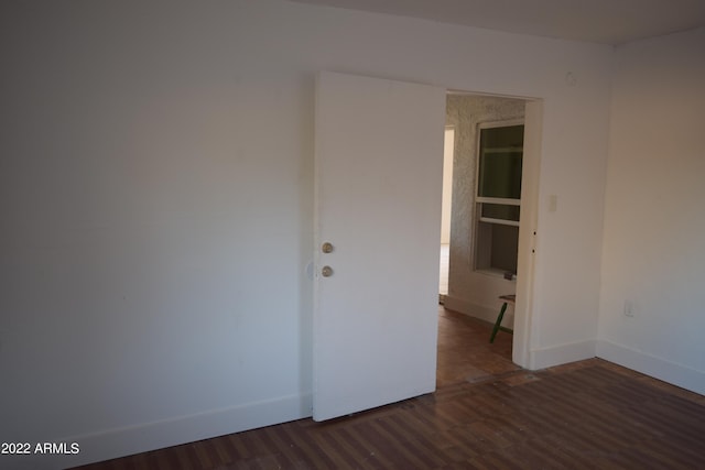 empty room with dark hardwood / wood-style flooring