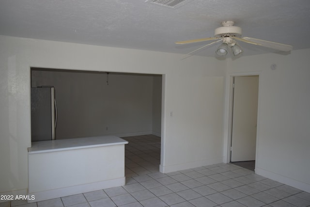 tiled spare room featuring ceiling fan