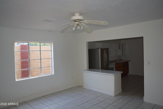 unfurnished room with light tile floors and ceiling fan