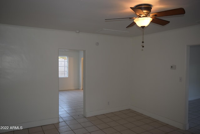 unfurnished room featuring ceiling fan, ornamental molding, and light tile floors