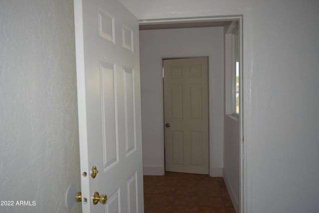 corridor featuring dark tile floors