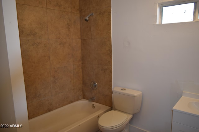 full bathroom featuring tiled shower / bath combo, toilet, and vanity