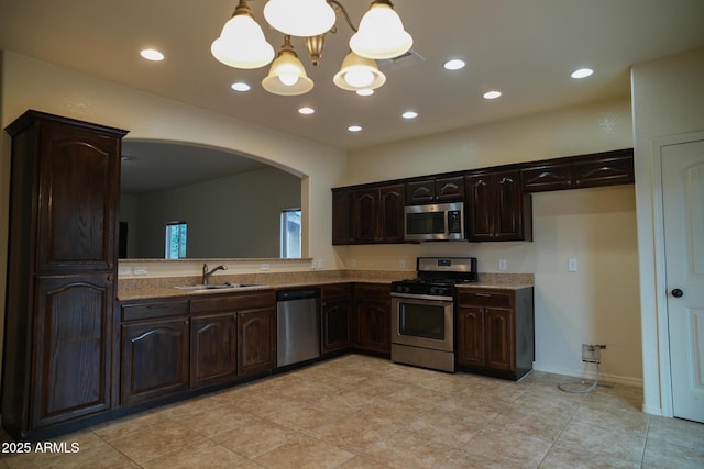 4246 Kings Canyon Way, Sierra Vista, AZ 85650 - kitchen featuring stainless steel appliances, a sink, arched walkways, a chandelier, and dark brown cabinetry