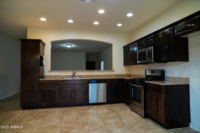 4246 Kings Canyon Way, Sierra Vista, AZ 85650 - kitchen featuring appliances with stainless steel finishes, a sink, recessed lighting, arched walkways, and light stone counters