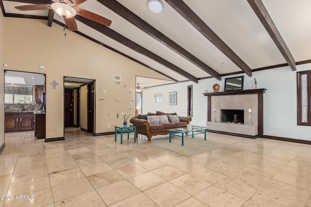 11237 N 15th Ln, Phoenix, AZ 85029 - living area featuring ceiling fan, beam ceiling, baseboards, a tiled fireplace, and high vaulted ceiling
