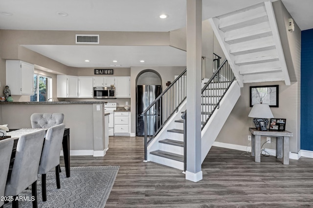 interior space featuring dark wood-style flooring, recessed lighting, visible vents, stairway, and baseboards