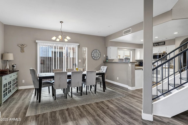 dining space with baseboards, visible vents, dark wood-type flooring, an inviting chandelier, and stairs