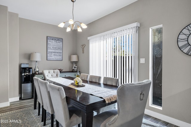 dining area with a notable chandelier, baseboards, and wood finished floors