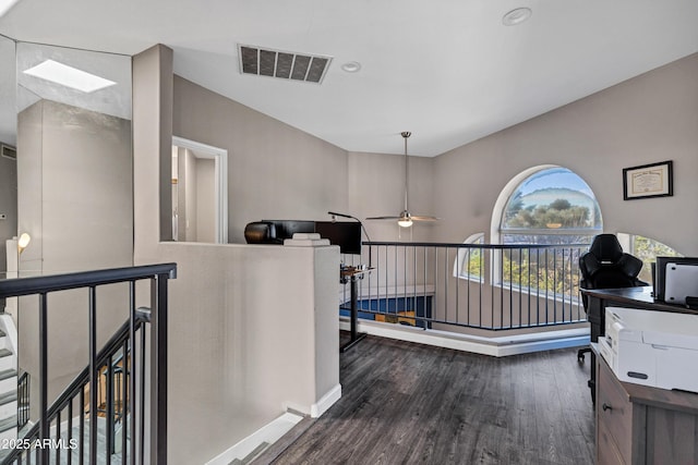 hall with wood finished floors, an upstairs landing, and visible vents