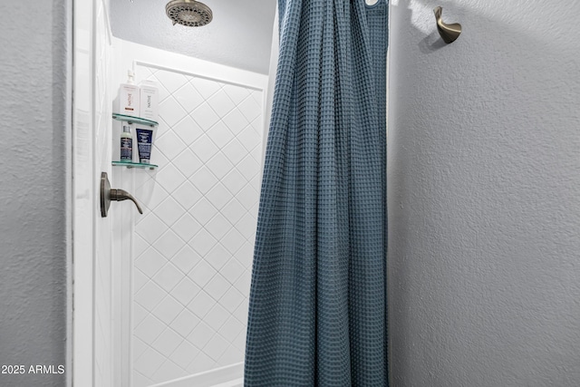 details featuring a textured wall and curtained shower