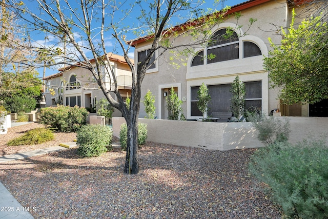 view of home's exterior featuring a fenced front yard, a tiled roof, and stucco siding